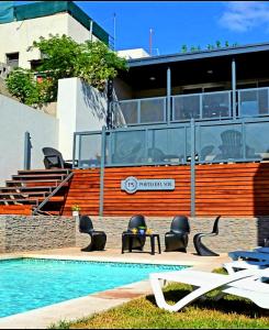 a pool with chairs and a table next to a building at Apart Porto del Sol by CPH in Villa Carlos Paz