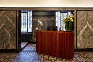 eine Lobby mit einer Rezeption mit einer Blumenvase in der Unterkunft Hotel Indigo The Hague - Palace Noordeinde, an IHG Hotel in Den Haag