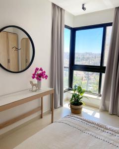 a bedroom with a large mirror and a window at Nu Fifty Two in Amman