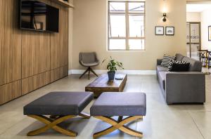 een woonkamer met 2 stoelen en een bank bij Hotel Santa Cruz in Santa Cruz do Sul