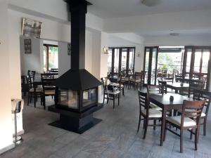 a restaurant with a fireplace and tables and chairs at Theoxenia in Kalopanayiotis