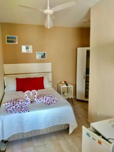 a bedroom with a bed with a teddy bear on it at Pontal Praia Suítes in Arraial do Cabo