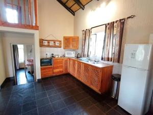 a kitchen with a white refrigerator and a sink at Idle & Wild Chalet in Hazyview