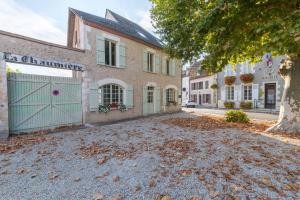 a driveway in front of a building with a green garage at La Chaumière in Ousson-sur-Loire