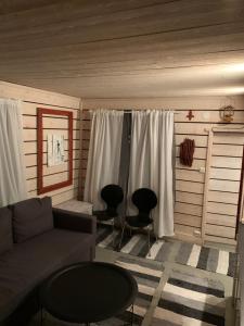 een woonkamer met een bank en 2 stoelen bij Stugan med Bryggan i Gamla Staden in Eskilstuna