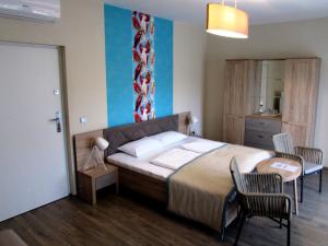 1 dormitorio con 1 cama, mesa y sillas en Napsugár Club és Panzió en Fonyód