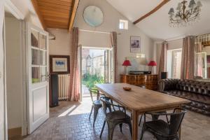 sala de estar con mesa de madera y sillas en La Chaumière, en Ousson-sur-Loire