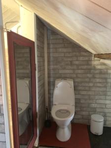 een badkamer met een toilet in een bakstenen muur bij Stugan med Bryggan i Gamla Staden in Eskilstuna