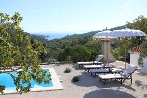 un grupo de sillas y una sombrilla junto a una piscina en Casa Katrida en Selca