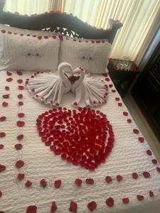 Una cama con un corazón hecho de rosas rojas en Hotel Sipa, en Duitama