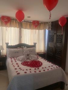 a bedroom with a bed with red hearts and balloons at Hotel Sipa in Duitama