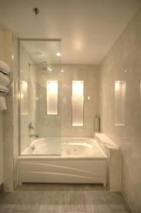 a large bathroom with a tub and a shower at Armon Plaza Montreal Airpt, Trademark Collection by Wyndham in Montreal