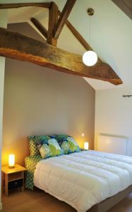 a bedroom with a large bed with a wooden ceiling at La maison d'Henriette in Lugny