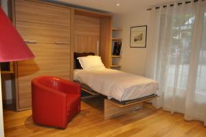 ル・ブール・ドアザンにあるChalet la Cachette Cyclists & Skiersのベッドルーム1室(ベッド1台、赤い椅子付)