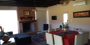 a living room with a table and a fireplace at Sol de las Sierras Zonda PREVIAJE in Zonda