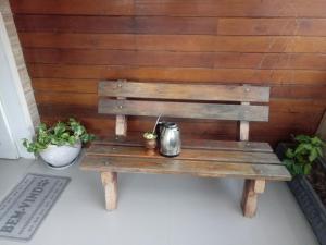 a wooden bench with a tea kettle on it at Casa da Colina in Bento Gonçalves