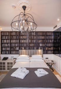 a bedroom with a large bed and a chandelier at Heritage Villa Nobile in Dubrovnik
