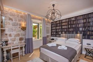 a bedroom with a large bed and a chandelier at Heritage Villa Nobile in Dubrovnik