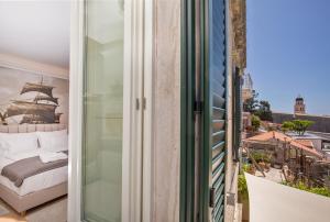 a balcony with a bed and a window at Heritage Villa Nobile in Dubrovnik