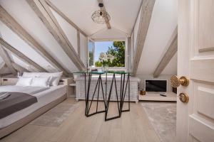 a bedroom with a bed and a window and a table at Heritage Villa Nobile in Dubrovnik