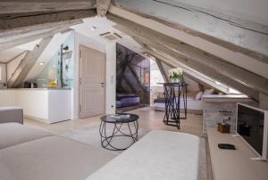 an attic living room with white furniture and wooden ceilings at Heritage Villa Nobile in Dubrovnik
