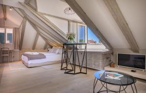 a attic bedroom with a bed and a tv at Heritage Villa Nobile in Dubrovnik
