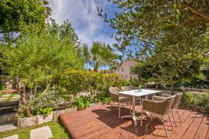 a wooden deck with a table and chairs in a garden at Heritage Villa Nobile in Dubrovnik
