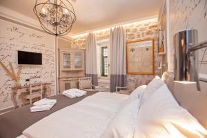 a bedroom with a large white bed and a desk at Heritage Villa Nobile in Dubrovnik