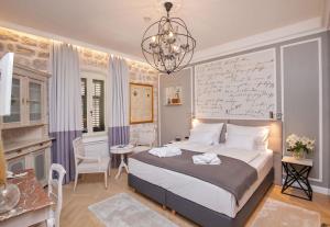 a bedroom with a large bed and a chandelier at Heritage Villa Nobile in Dubrovnik