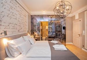 a bedroom with a white bed with a writing wall at Heritage Villa Nobile in Dubrovnik