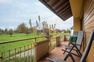een balkon met stoelen en uitzicht op een veld bij Ferienwohnung Steinhilber 2 in Eriskirch