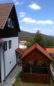 哈爾吉塔白的住宿－Hargitafürdői Vendégház，房屋旁的带红色屋顶的谷仓