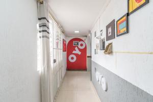 un couloir avec une porte rouge dans une chambre dans l'établissement OYO Hotel San Remo, São Paulo, à São Paulo