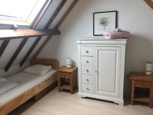 een slaapkamer met een bed en een witte dressoir bij Holiday home Vossennest in Veere