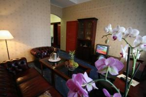 - un salon avec un canapé et une table fleurie dans l'établissement Draakon Hotel, à Tartu