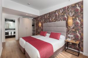 Kumara Serenoa By Lopesan Hotels في ماسبالوماس: غرفة نوم بسرير كبير مع بطانية حمراء