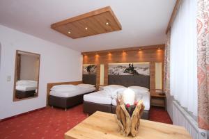 una camera d'albergo con due letti e un tavolo di Hotel Garni Corinna a Ischgl