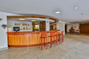 a bar with red stools in a large room at Flat Plaza Hotel - Setor de Hotéis Norte in Brasília