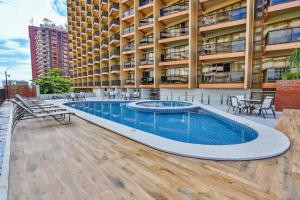 a building with a swimming pool in front of a building at Flat Plaza Hotel - Setor de Hotéis Norte in Brasília