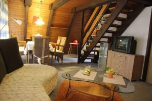a living room with a couch and a tv at Ferienhaus Kornblume in Ronshausen