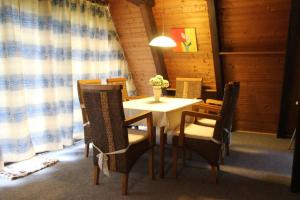 a dining room with a table with chairs and a lamp at Ferienhaus Kornblume in Ronshausen