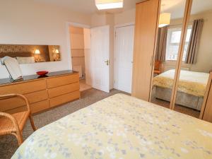 a bedroom with a bed and a dresser and a mirror at The Admiral in Coleraine