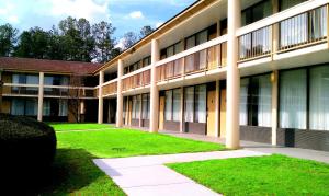 um grande edifício com relva à frente em Days Inn & Conf Center by Wyndham Southern Pines Pinehurst em Southern Pines