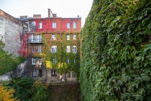 an ivy covered building in front of a building at Levia apartment-with 2 bedrooms in the old town in Lviv