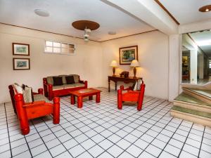 Hotel D Gomar في إيسلا موخيريس: غرفة معيشة مع كراسي حمراء وطاولة