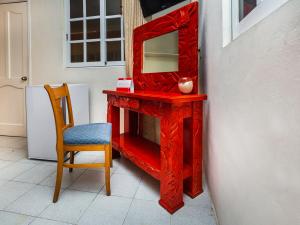 a red dressing table with a mirror and a chair at Hotel D Gomar in Isla Mujeres