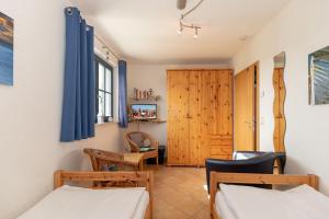 キュールングスボルンにあるBuesumer-Ring-Haus-Leuchtturmblick-295のベッドルーム1室(ベッド2台、木製キャビネット付)
