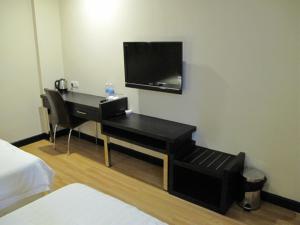a hotel room with a desk with a television on the wall at Labuk Hotel in Sandakan