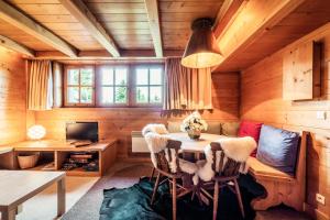 ムジェーヴにあるCosy and comfortable studio ski-in and walking distance from the slopesのキャビン内のテーブルと椅子付きの部屋