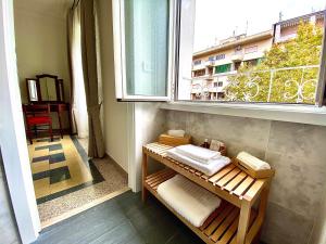 Zimmer mit einem Fenster und einer Bank mit Handtüchern in der Unterkunft Domus Delphi in Rom